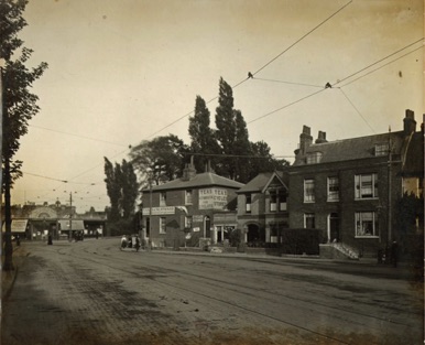 The camera is looking toward the Kingston Bridge approach from a vantage point opposite the "Old Kings Head" sometime in the period 1912 - 1917. On the right are The Gate House and Fern Glen. The two buildings immediately beyond have disappeared and are now the site of the Hampton Wick War Memorial and its gardens. In the distance on the far left of the picture is Hampton Court Parade of five shops.
